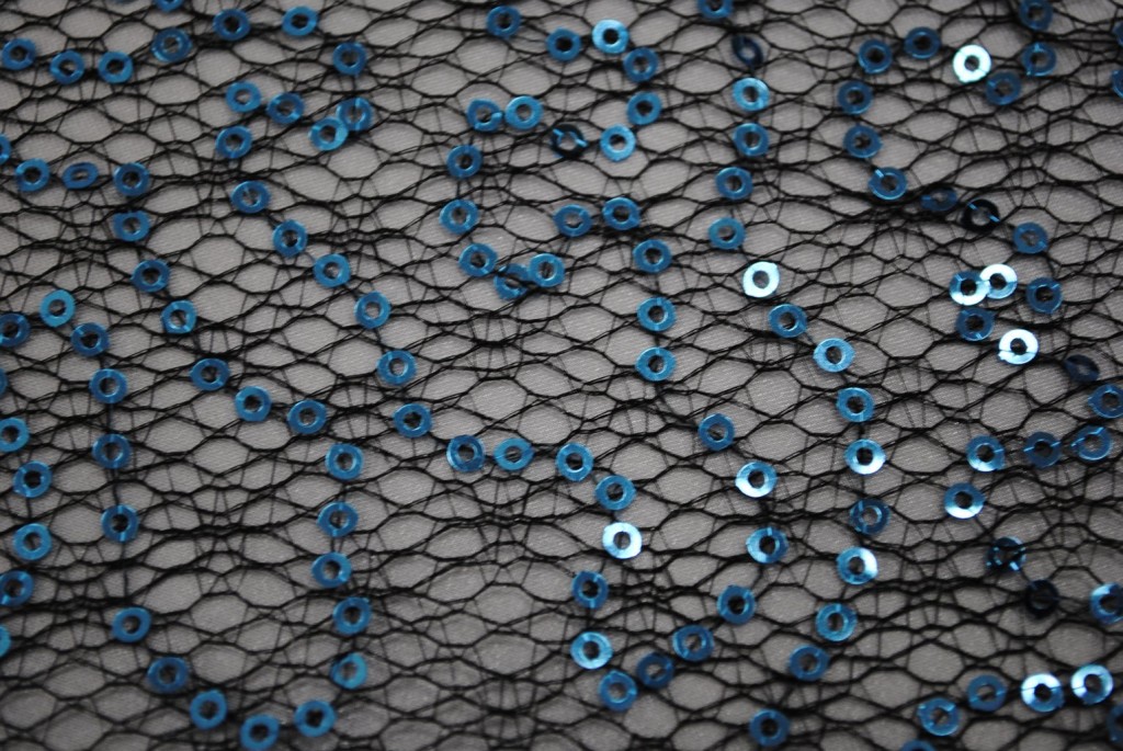 Turquoise sequins on black spider mesh fabric