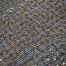 Gold sequins on black spider mesh fabric - Fabric Universe
